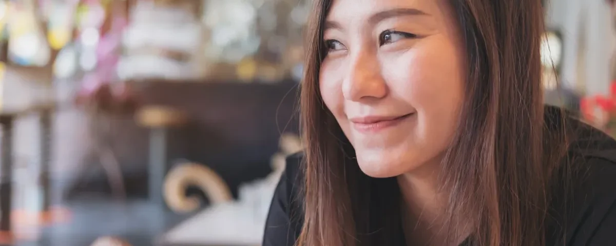 Woman smiling relaxed at cafe table
