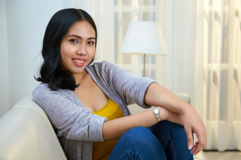 Woman relaxing on couch in bright indoor setting