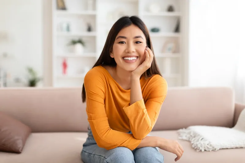 Woman relaxing at home on couch with genuine smile