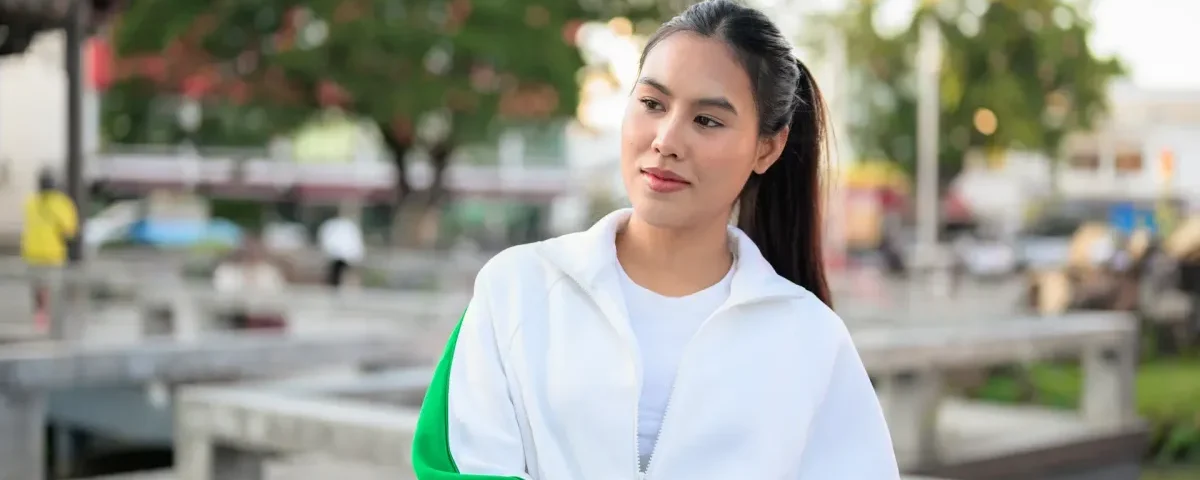 Woman in white tracksuit relaxing in urban park setting