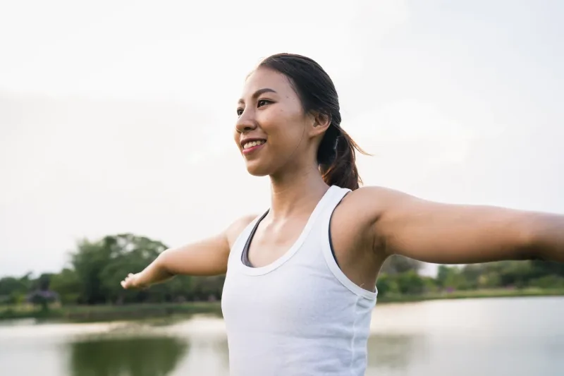 Woman smiling outdoors in natural green environment enjoying outdoor activity