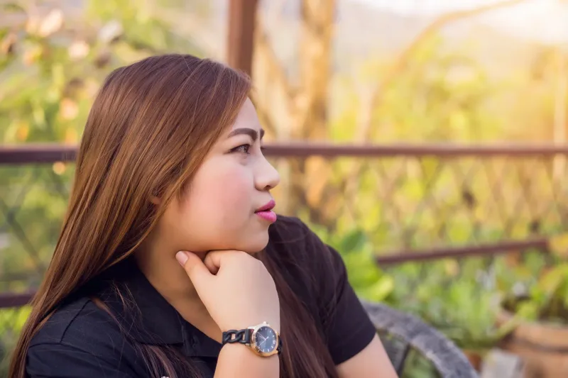 Woman in contemplative profile outdoors in natural setting