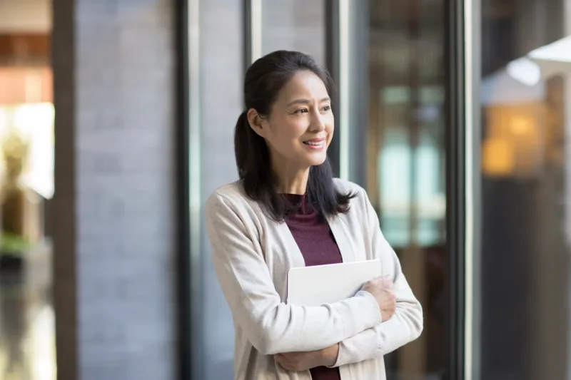 Professional woman in modern office holding tablet, confident stance
