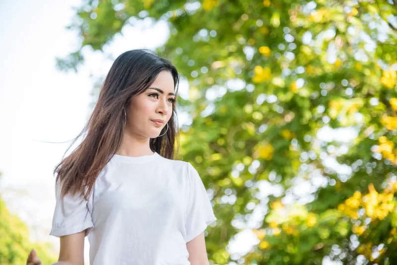 Woman with genuine smile in garden setting, conveying comfort and emotional readiness for commitment