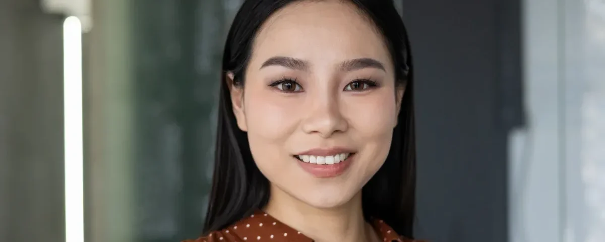 Professional woman in modern office smiling with confidence and warmth