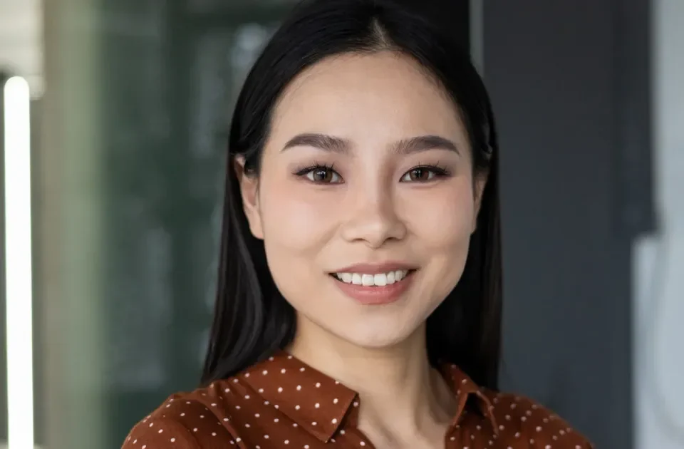 Professional woman in modern office smiling with confidence and warmth