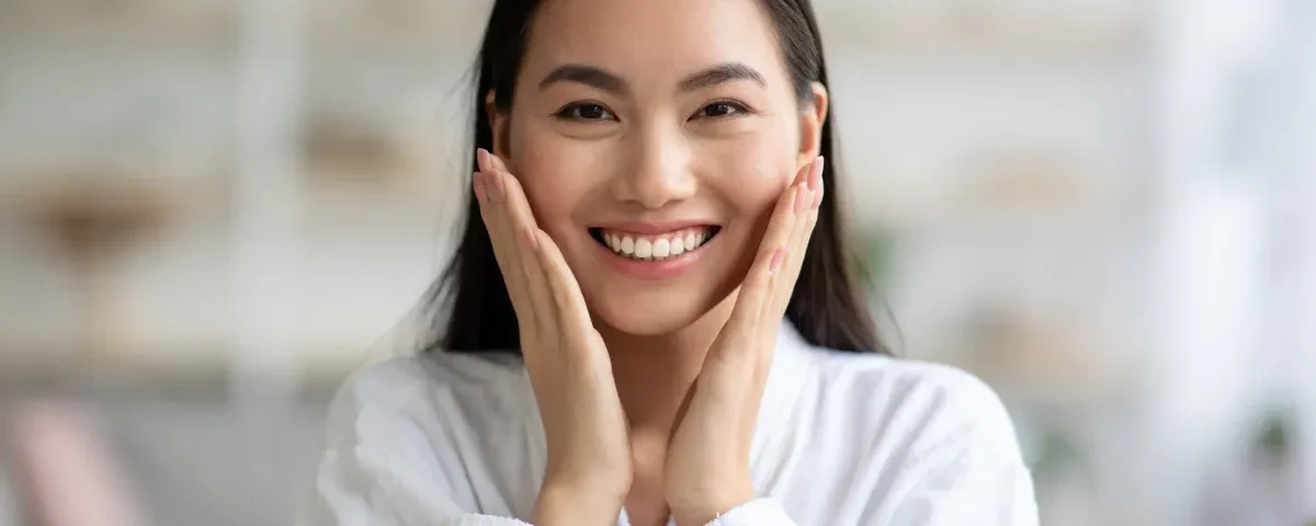 Woman smiling with hands near face, relaxed and confident demeanor