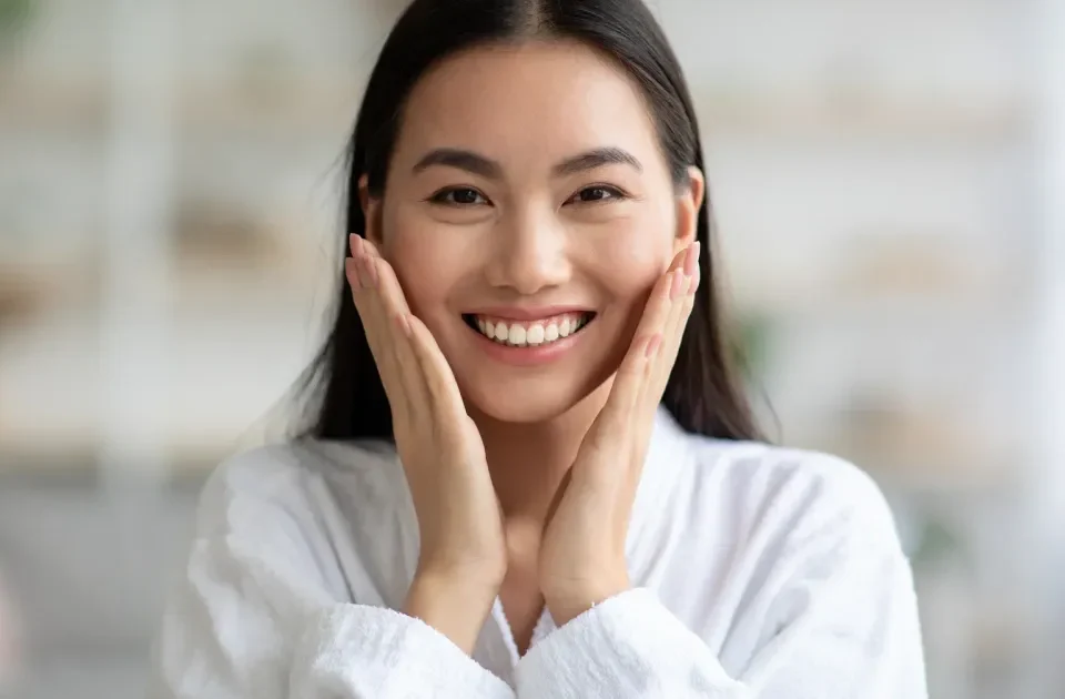 Woman smiling with hands near face, relaxed and confident demeanor