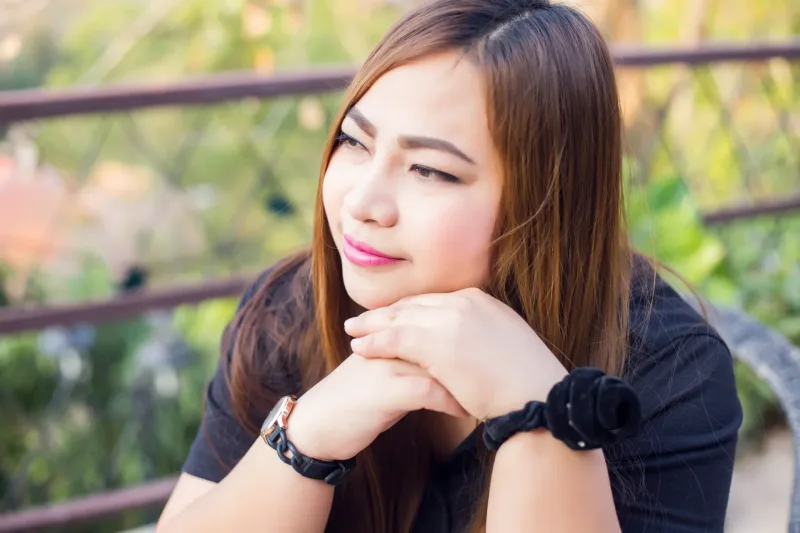 Woman contemplative outdoors, thoughtful expression with natural lighting