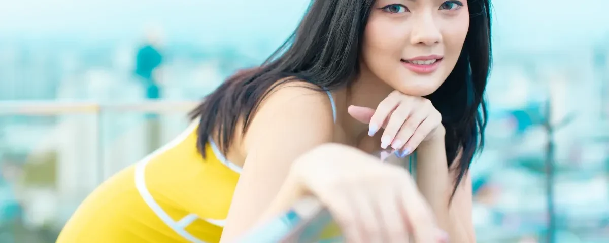 Woman smiling confidently on rooftop with warm, approachable demeanor