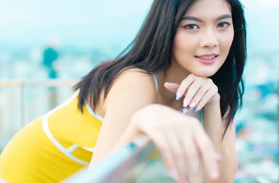 Woman smiling confidently on rooftop with warm, approachable demeanor