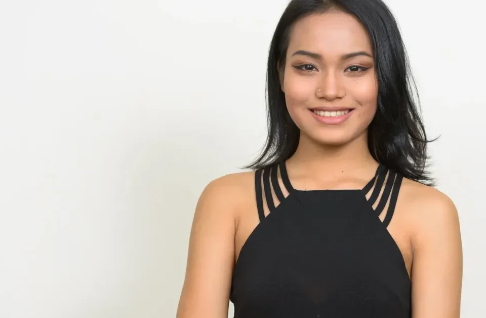 Woman smiling confidently indoors, approachable and friendly demeanor