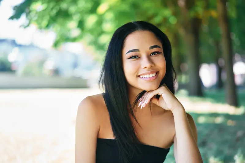 Woman outdoors with a warm, genuine smile and natural confidence