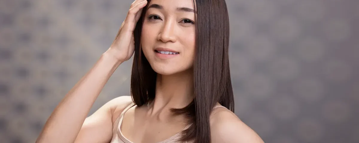 Woman with confident smile and warm expression in studio setting