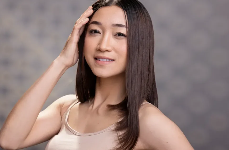 Woman with confident smile and warm expression in studio setting