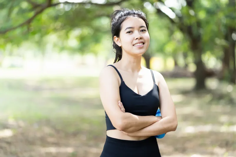 Woman standing confidently outdoors with engaged, positive expression