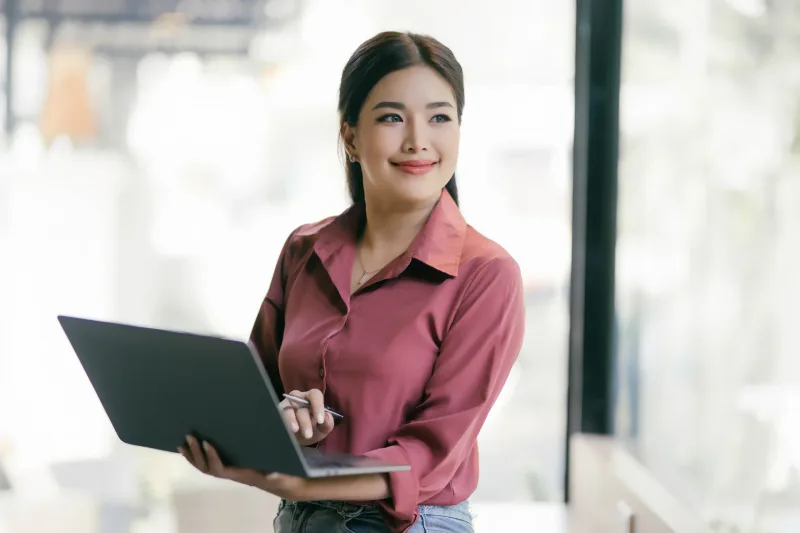 Confident woman in modern workspace with technology