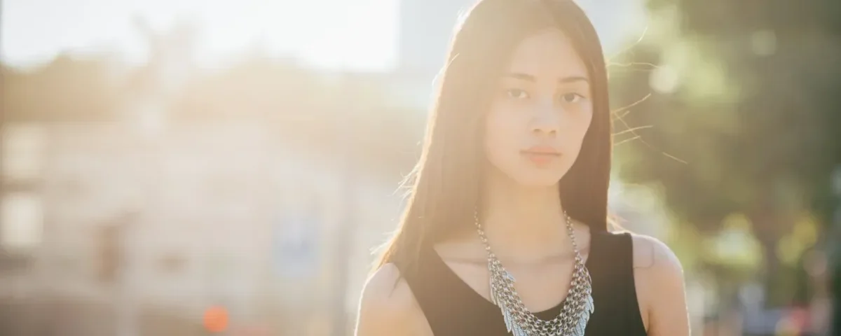 Woman with thoughtful expression in urban setting at golden hour
