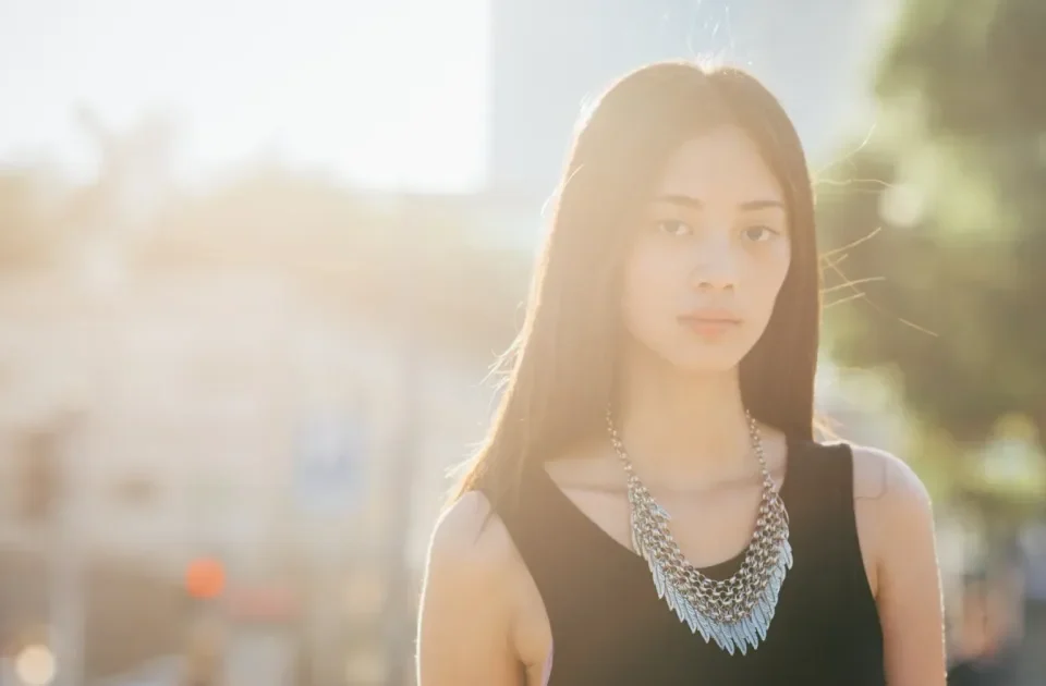 Woman with thoughtful expression in urban setting at golden hour