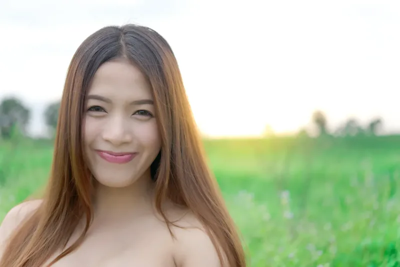 Warm, smiling woman in natural outdoor setting representing how Filipino courtship values family involvement and genuine connection