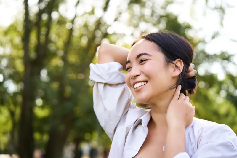 Woman outdoors in casual white shirt, contemplative expression suggesting the deliberate, patient nature of ligaw courtship process