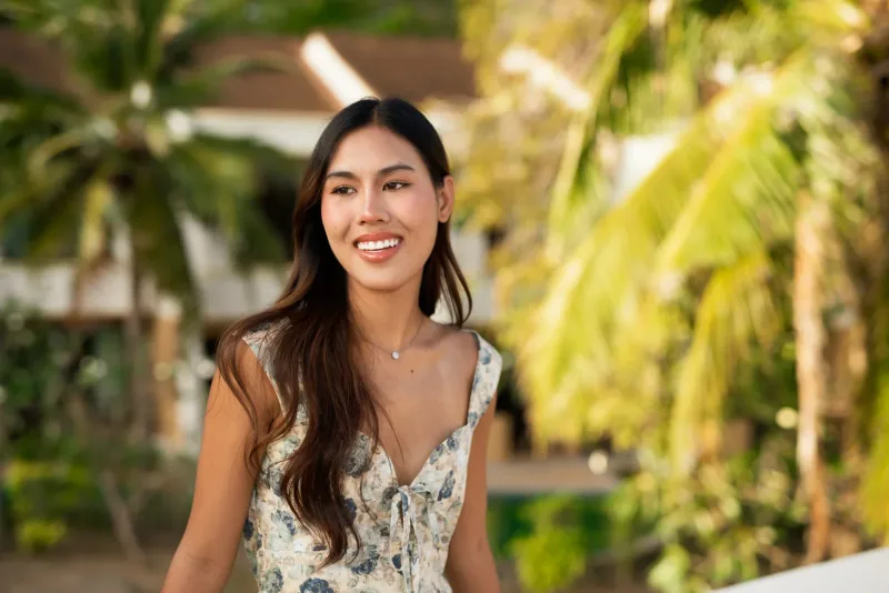 Filipina woman in tropical garden setting smiling peacefully