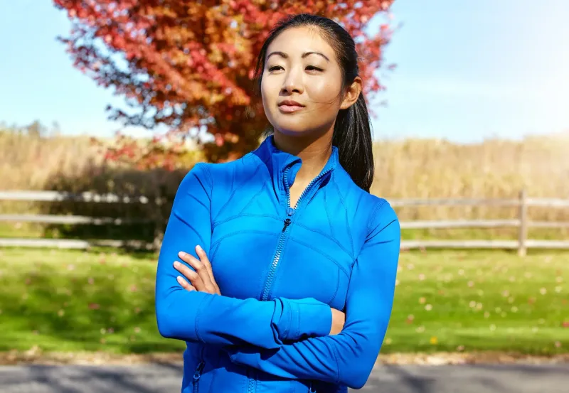 Woman in athletic wear standing confidently outdoors