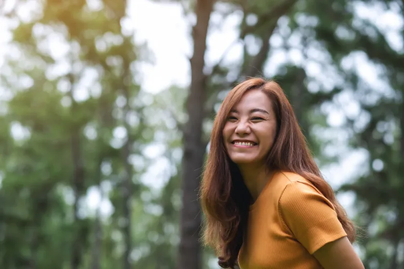 Woman smiling outdoors in golden-hour light, natural and warm