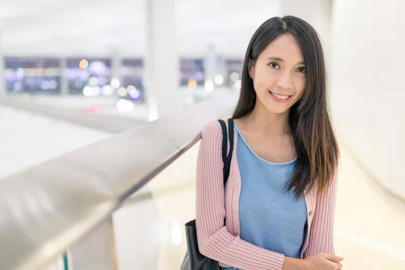 Woman smiling warmly in a casual indoor setting, approachable and at ease