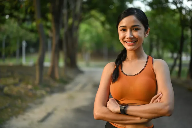 Athletic woman smiling confidently outdoors, radiating positive energy