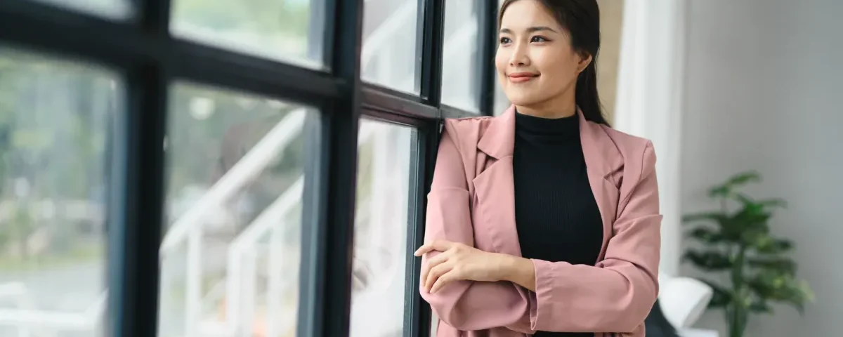 Filipina smiling confidently in modern office setting, composed expression reflecting cultural awareness