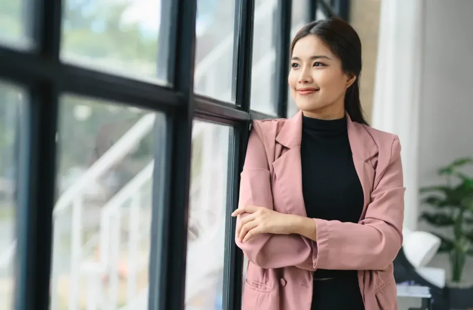 Filipina smiling confidently in modern office setting, composed expression reflecting cultural awareness