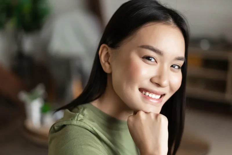 Woman smiling warmly in natural indoor light
