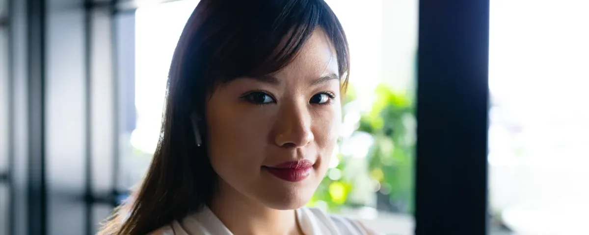 Woman in composed portrait by window with natural light