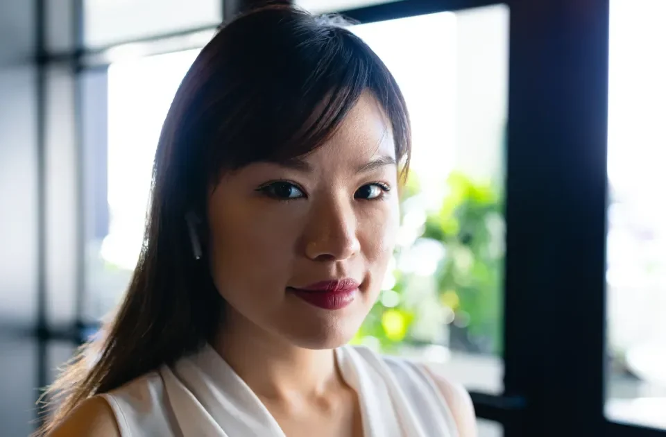 Woman in composed portrait by window with natural light