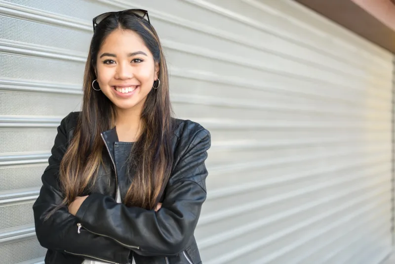 Smiling young Filipina in casual black leather jacket, representing the confident commitment women make when deciding to introduce partners to family.