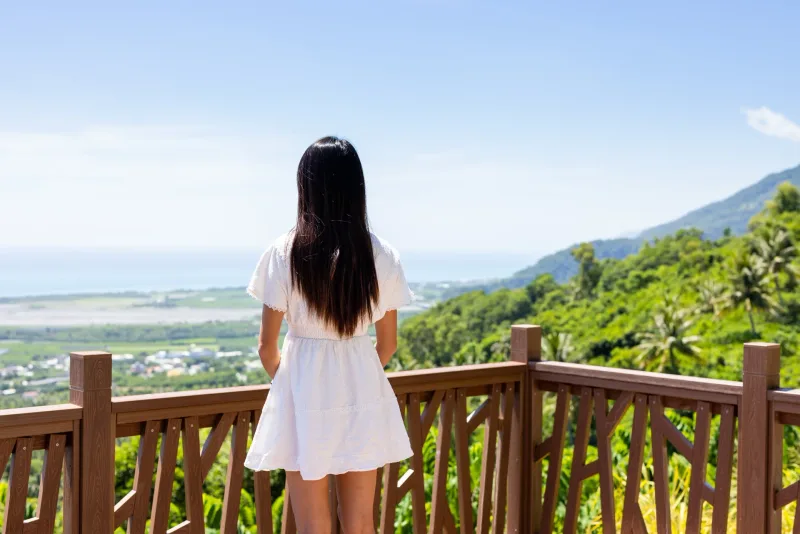 Woman standing at scenic mountain overlook in white dress, suggesting thoughtful relationship pacing