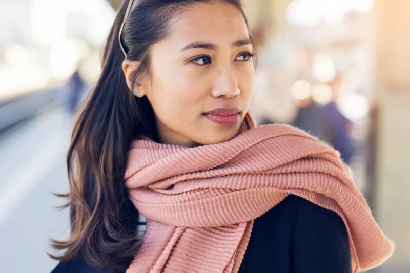 Woman in urban setting with thoughtful expression, reflecting city-center meeting locations