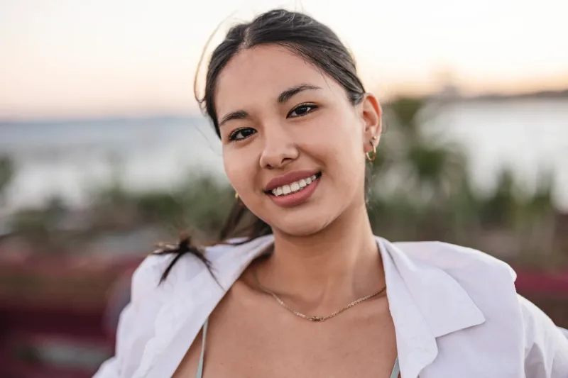 Close-up portrait of smiling woman at sunset, conveying genuine care and connection