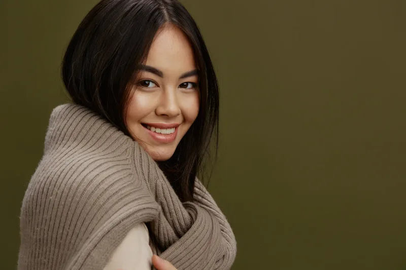 Woman in brown sweater with confident smile, showing emotional openness