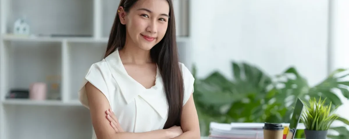 Confident Filipina professional smiling in modern office setting, embodying emotional maturity and direct communication valued in international relationships