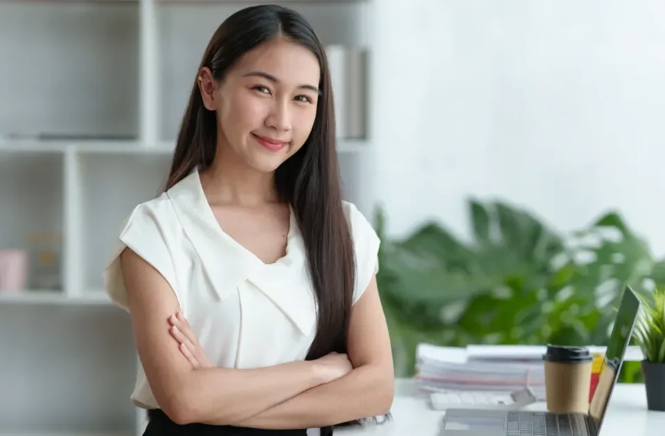 Confident Filipina professional smiling in modern office setting, embodying emotional maturity and direct communication valued in international relationships