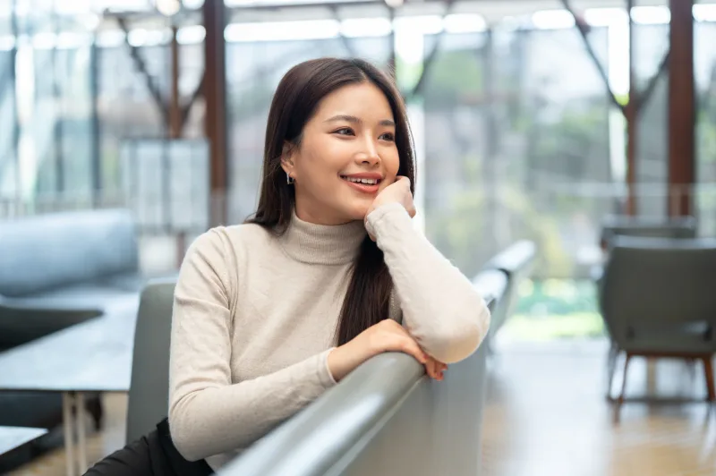 Woman resting thoughtfully indoors with natural light, reflecting the genuine care and emotional investment Filipinas prioritize in relationships
