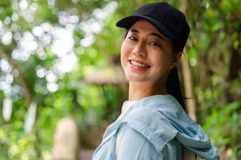 Woman smiling in tropical forest setting, capturing the approachable and genuine engagement style characteristic of Philippines dating culture